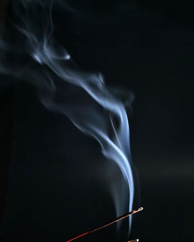 A cigarette is lit up by the smoke.