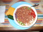 A bowl of beans and cheese on the table.