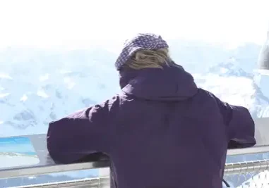 A person standing on top of a building looking at the sky.