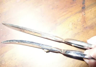 A pair of scissors sitting on top of a wooden table.